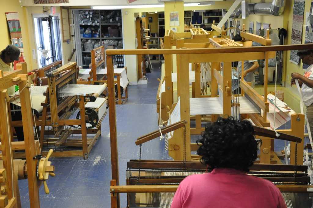 Weavehouse workers making products on donated looms using recycled materials.