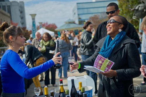 Margo Kemmerer (left) pours a glass of wine for Shauntice Allen during the Decatur Wine Festival on Saturday, November 9, 2013. Photo by: Jonathan Phillips