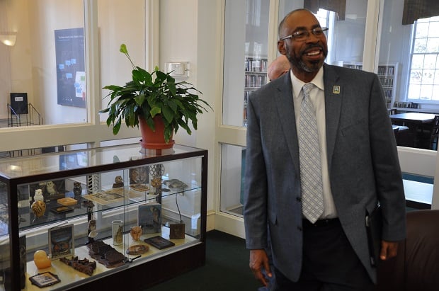 Greg White, the city of Decatur's Active Living Director, shows of a display case containing some of his mom's owl collection. 