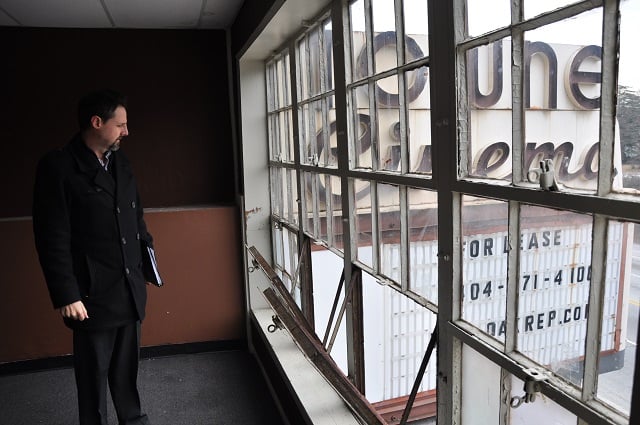 Fisher Paty, with Oakhurst Realty Partners, looks out the window of the projector room of the Towne Cinema in Avondale Estates. Photo by: Dan Whisenhunt