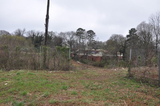 A developer wants to turn this overgrown lot and the adjacent apartments behind it into a multifamily project. Photo by Dan Whisenhunt