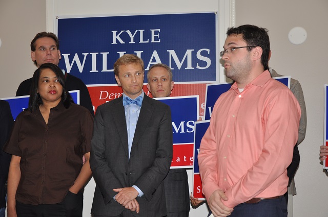 Kyle Williams, center, listens while Ian Sugar, right, Deputy Political Director with the Gay and Lesbian Victory Fund, speaks on his behalf during a May 15 press conference. Photo by Dan Whisenhunt