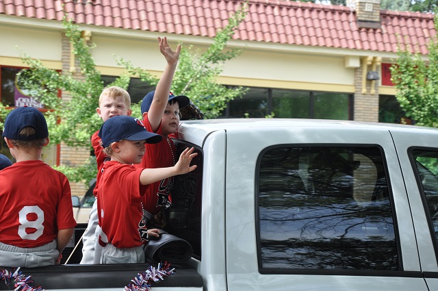 Players in Decatur's youth baseball league wave at the crowd during a June 7 parade. Photo by Dan Whisenhunt