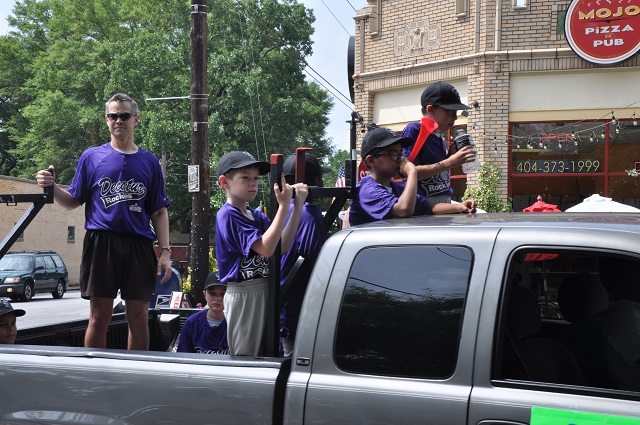 Players in Decatur's youth baseball league wave at the crowd during a June 7 parade. Photo by Dan Whisenhunt