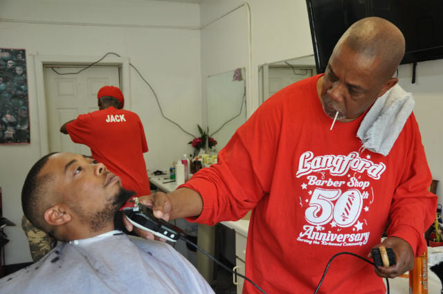 Stanley Kellam puts the finishing touches on the beard of long-time customer Jeff Ardford. Photo by Dan Whisenhunt