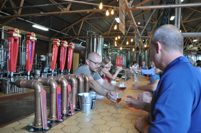 June 12, 2014: Guests line up at the bar at the grand opening of the Wild Heaven brewery in Avondale Estates. Photo by Dan Whisenhunt
