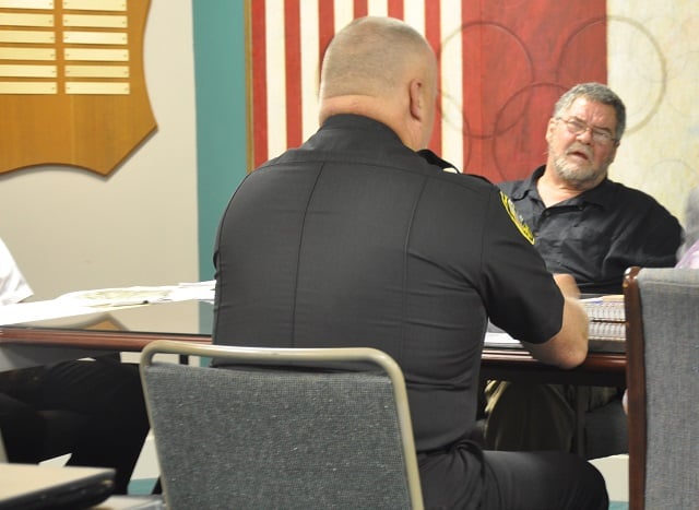 July 23, 2014: City Commissioner Randy Beebe listens to Police Chief Gary Broden explain how House Bill 60 will affect Avondale Estates. Photo by Dan Whisenhunt