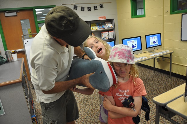 MIke Barcik goofs around with daughters Jude Harper and Lily Mae in the Westchester Elementary library on July 31. Photo by Dan Whisenhunt