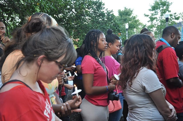Protesters outside the DeKalb County Courthouse in Decatur, Ga. bow their heads in a moment of silence on Aug. 14, 2014. Several hundred protesters gathered in front of the Decatur Courthouse to hold a moment of silence for Michael Brown, a teenager killed by a police officer in Ferguson, Mo. The case, and the subsequent decision not to indict the officer involved, touched of months of protests around the country. The protests continue. Photo by Dan Whisenhunt