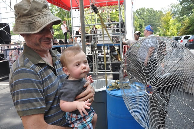 A father helps his son cool off during this year's Decatur BBQ and Bluegrass Festival.  Photo by Dan Whisenhunt 