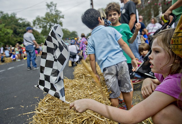 Photo: Jonathan Phillips Calliope Snook waves a checkered flag during the 4th annual Madison Ave. Soap Box Derby in Decatur on Saturday, September 27, 2014.