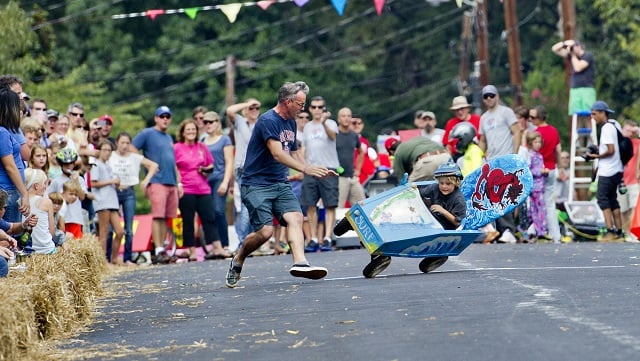 Photo: Jonathan Phillips Rowan Wall (right) starts to flip as his father Chad rushes to his aid during the 4th annual Madison Ave. Soap Box Derby in Decatur on Saturday, September 27, 2014.