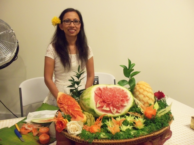Bonnie Kessung stands behind her fruit and vegetable carving which includes butterflies made of carrots and a flower arrangement carved into a watermelon. Photo by Dena Mellick 