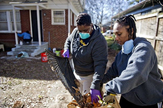 Maketa Colbert (right) and Andrea Parker clean up Annie Harper's back yard during the Decatur Martin Luther King Jr. Service Project weekend on Sunday, January 18, 2015. Photo by Jonathan Phillips