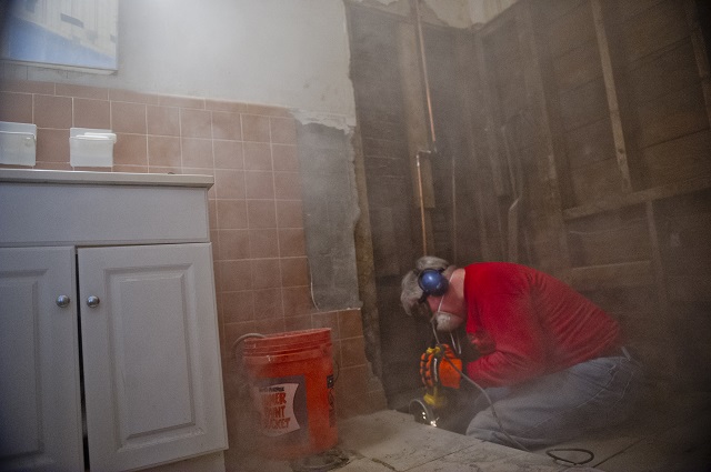 Dust flies everywhere as Phil Houck helps install a new handicap accessible shower in Inez Baughns home during the Decatur Martin Luther King Jr. Service Project weekend on Sunday, January 18, 2015. Photo by Jonathan Phillips