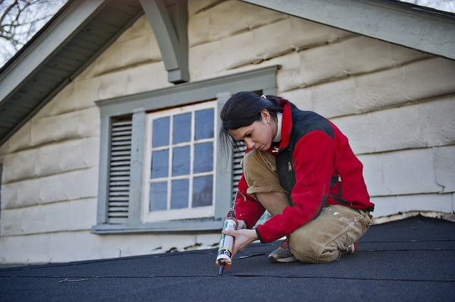 Ashley Lytle seals roof shingles during the Decatur Martin Luther King Jr. Service Project weekend on Sunday, January 18, 2015.  Photo by Jonathan Phillips