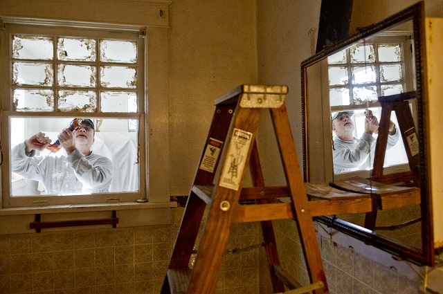 Charles Absher seals a window in Buelah Rosser's bathroom during the Decatur Martin Luther King Jr. Service Project weekend on Sunday, January 18, 2015. Photo by Jonathan Phillips