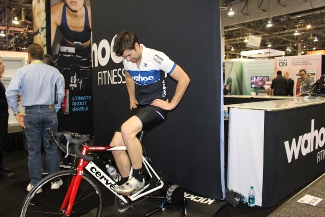 An athlete shows the capabilities of the KICKR cycling trainer at the CES Wahoo Fitness booth in Las Vegas. Photo by Dena Mellick