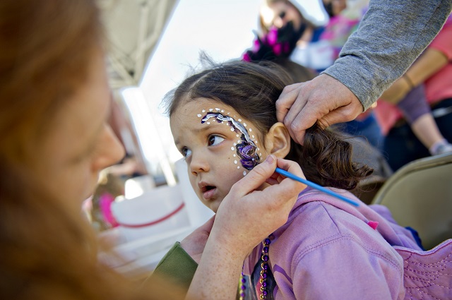 Maya Deodhar (center) gets her face painted as she prepares for the start of the Mead Road Mardi Gras parade in Decatur on Saturday, Feb. 7, 2015. Photo by: Jonathan Phillips