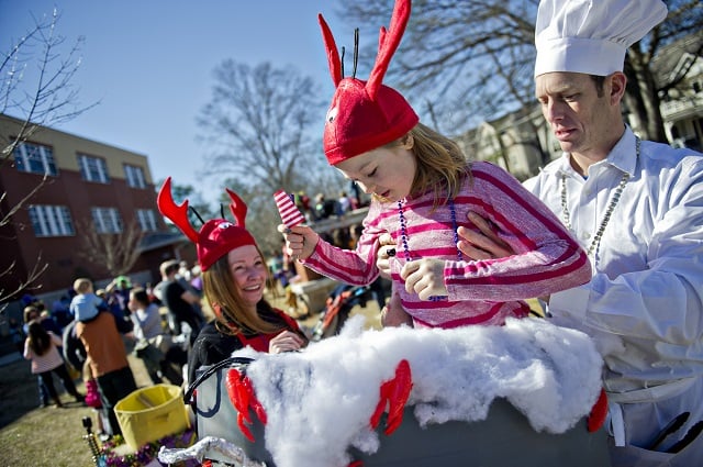 Mike Murphy (right) lifts his daughter Teagan into a crawfish boiling pot. Photo by Jonathan Phillips