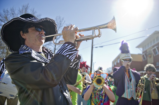 John Moredock (left) blasts his trumpet to start off the Mead Road Mardi Gras Parade. Photo by Jonathan Phillips
