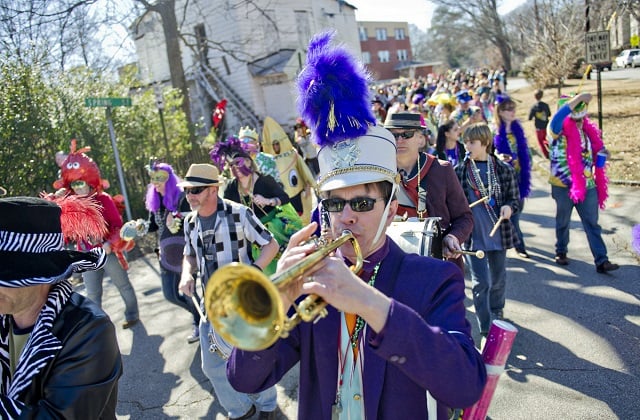 Bo Emerson (center) plays the trumpet as he marches down Oakview Road during the 2015 Mead Rd Mardi Gras parade. Photo by Jonathan Phillips