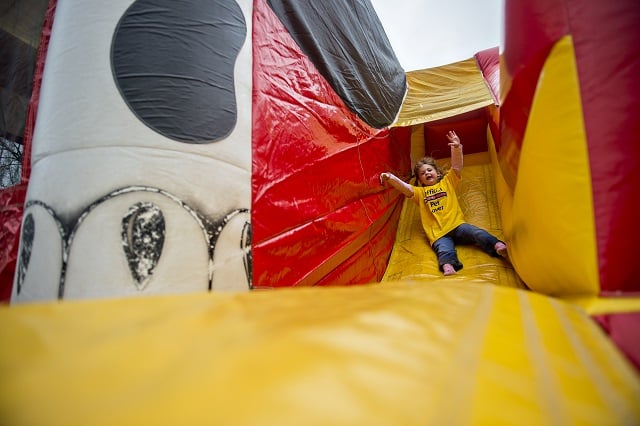 Lillian Fiebelkorn slides down an inflatable dog house. Photo by Jonathan Phillips