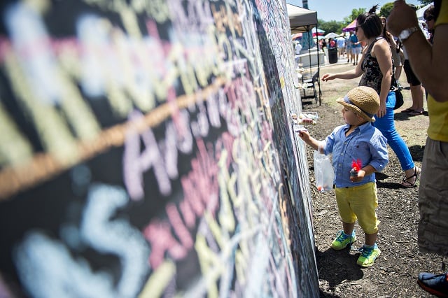 Niko Thomas writes a message about his future on a chalkboard during the Decatur Arts Festival on Saturday. Photo: Jonathan Phillips