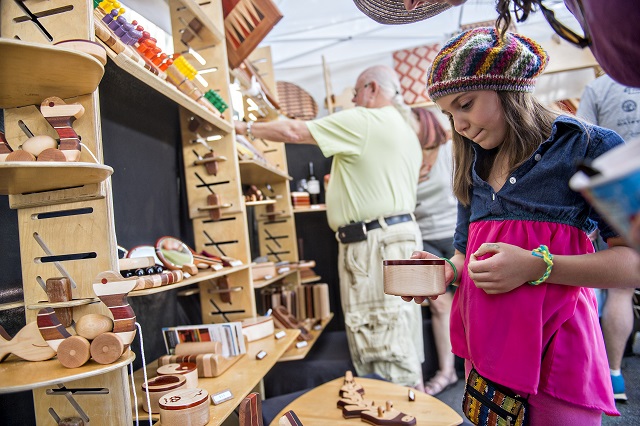 Sage Lovvorn picks out a wooden box in John Deveer's booth during the Decatur Arts Festival on Saturday. Photo: Jonathan Phillips