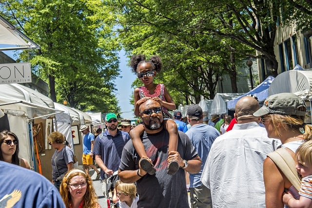 Zach Harris carries his daughter Kampbell on his shoulders as they walk past artist booths during the Decatur Arts Festival on Saturday. Photo: Jonathan Phillips