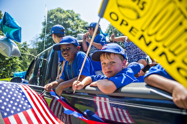 Teams with the Decatur Youth Baseball program ride in the back of trucks down East Lake Drive during a parade to celebrate opening day of the season on Saturday. Photo: Jonathan Phillips