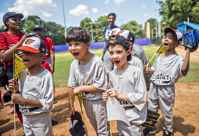Aidan Knapp (center left) and his team cheer as the ceremony for the opening day of Decatur Youth Baseball comes to a close at Oakhurst Park. Photo: Jonathan Phillips