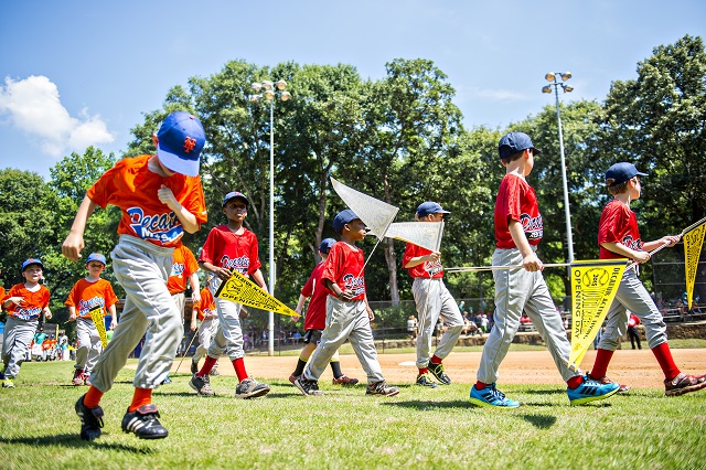 Teams with the Decatur Youth Baseball program walk out onto the field at Oakhurst Park for the opening day ceremony on Saturday. Photo: Jonathan Phillips