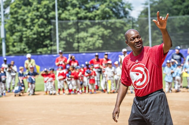 Mike Glenn (right), a former Atlanta Hawks player, walks out onto the field during the ceremony for the opening day of Decatur Youth Baseball at Oakhurst Park. Photo: Jonathan Phillips