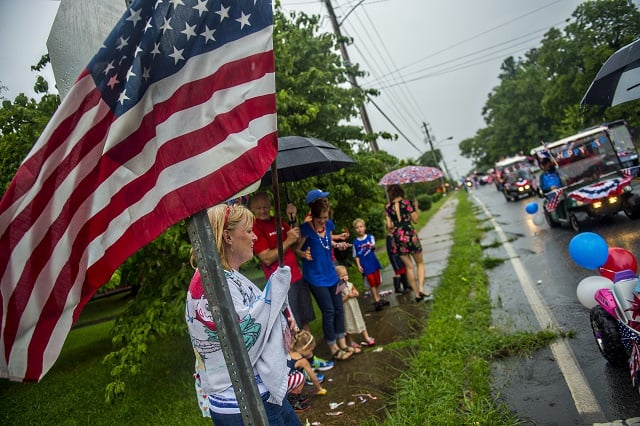 Beth Sparks holds an American flag as the Avondale Estates 4th of July Parade passes by on Saturday. Photo: Jonathan Phillips