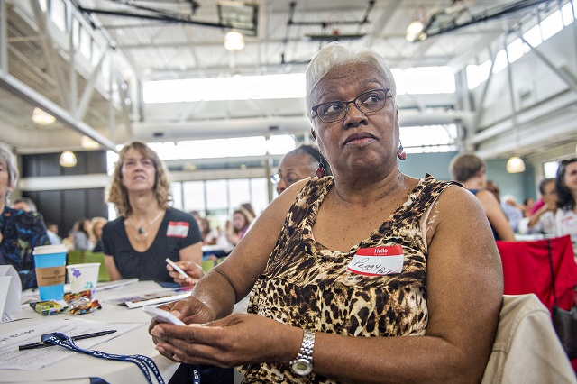 Peggy Parker uses a wireless transmitter to give her opinion on polling questions during Saturday's meeting at the Ebster Recreation Center. Photo: Jonathan Phillips