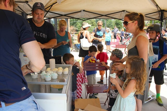 Marc Brennan scooping ice cream with Anna Berry & kids waiting. Photo by Rudi Bower