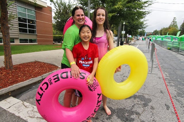 Sherry Murphy (left), Lily Fielscher (center) and Julia Fielscher came early to enjoy the slide after their previous time was cancelled. Photo by Travis Hudgons