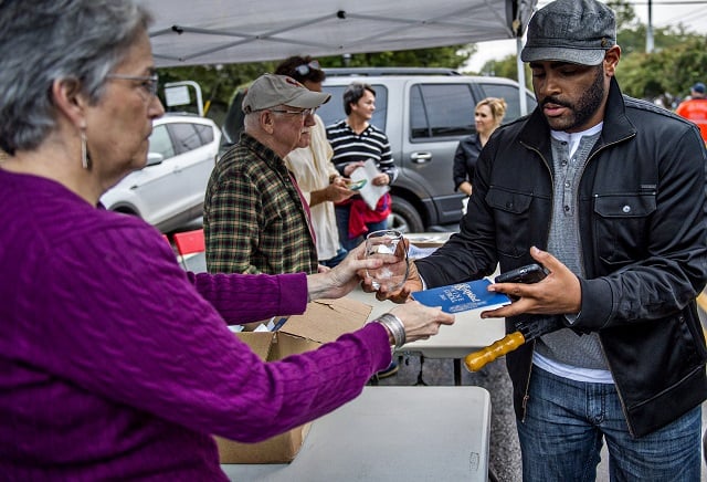 Kali Alford (right) takes his wine glass and booklet from Carol Kobayashi during the Kirkwood Wine Stroll on Friday. Photo: Jonathan Phillips
