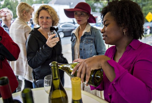 Natalie Richardson (right) pours a glass of wine for Virginia Vicory and Rebecca Bowden during the Kirkwood Wine Stroll on Friday. Photo: Jonathan Phillips