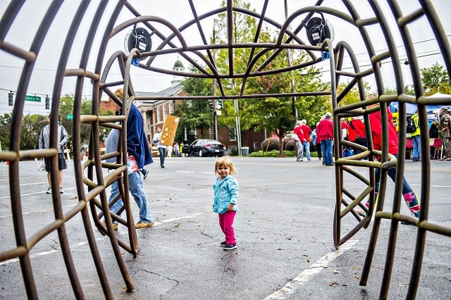 Addison Diethorn (center) walks through a fish skeleton made from metal during the Atlanta Maker Faire in Decatur on Saturday. Photo: Jonathan Phillips