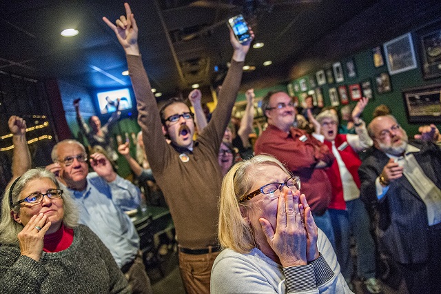 Melissa Montgomery (center) and Jon Fidler react as they watch poll results during the Dekalb Strong viewing party at Melton's app & tap on Tuesday. Photo: Jonathan Phillips