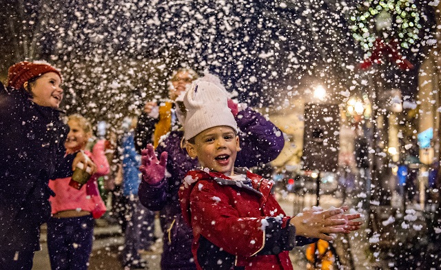 Jeremiah Hartman plays in fake snow as it falls in downtown Decatur during the annual lighting of the tree celebration on Thursday. Photo: Jonathan Phillips
