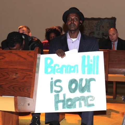 A Brannon Hill residents holds a sign during the town hall meeting. Photo by: Dyana Bagby