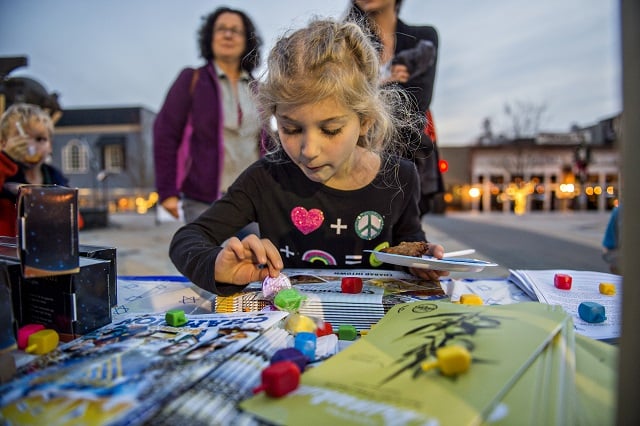 Delilah Wolf picks out a dreidel during the Chanukah celebration in Decatur Square on Thursday. Photo: Jonathan Phillips