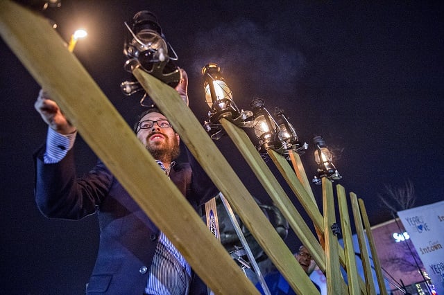 Rabbi Ari Sollish lights the giant menorah in Decatur Square during the Chanukah celebration on Thursday. Photo: Jonathan Phillips