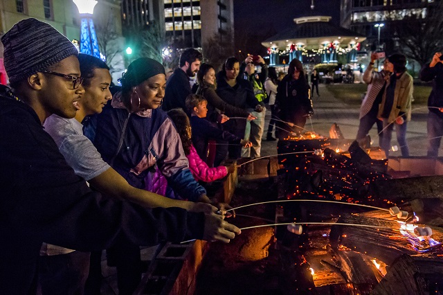 Zaylen McCoy (left), Marlon Sanchez and Lisa Beasley hold onto their sticks during the annual marshmallow roast at Decatur Square on Thursday. Photo: Jonathan Phillips