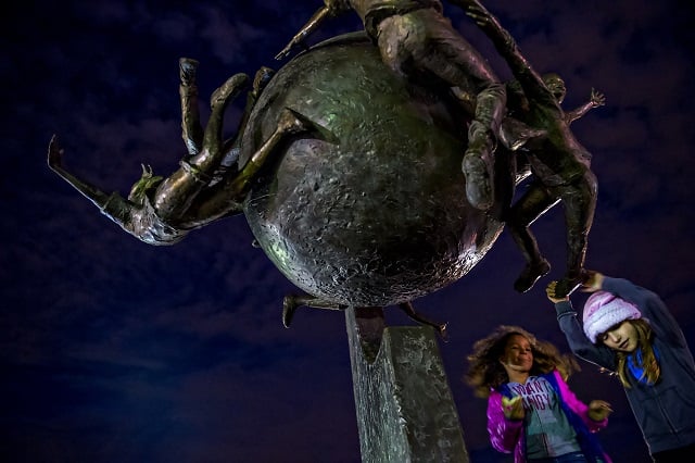 Dejah Morgan (left) and Abigail Morales-Vicaino play on the statue in Decatur Square before the start of the annual marshmallow roast on Thursday. Photo: Jonathan Phillips