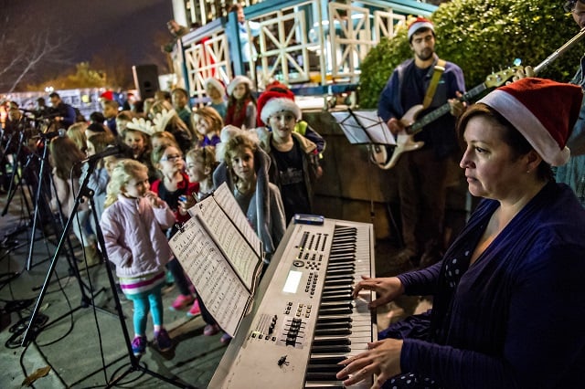 Diana Orozco (right) plays the keyboard as children sing Christmas carols during the annual marshmallow roast at Decatur Square on Thursday. Photo: Jonathan Phillips