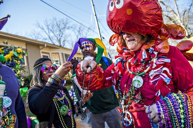 Dressed as a crawfish, Diane Loupe (right) hands a string of beads to Cindy Hampton before the start of the first annual LantaGras Parade in Kirkwood on Saturday. Photo: Jonathan Phillips
